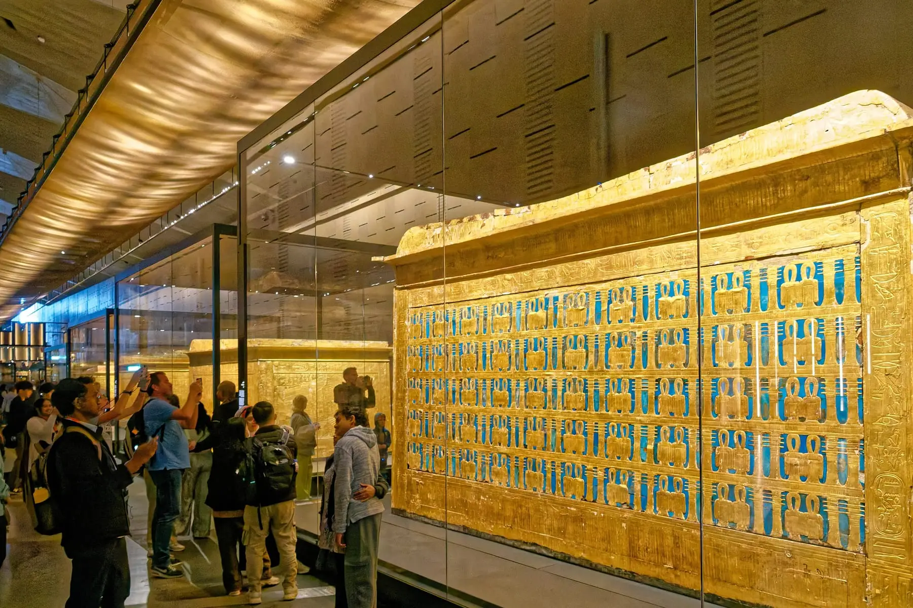 Visitors with a guide in front of a gilded shrine in the Tutankhamun galleries